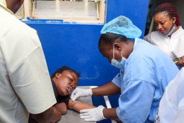 Lagos, Nijerya - 6 Eylül 2021: Şiddetli Ağrılarda Siyah Giyen Afrikalı Kadın Acil Operasyon için getirildi. Karın ağrısından kaynaklanan gözyaşları. Patlamış Apandisit