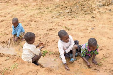 Abuja Nijerya - 2 Ağustos 2021: Güneşli bir günde Afrikalı Çocuklar Kum ile Oynuyor. Üçüncü Dünya Çocuklarıyla Eğlence Zamanı