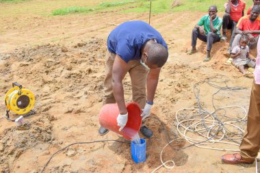 Jos East, Plateau State, Nijerya - 12 Mayıs 2021: Kırsal kesimlerde elle su kuyusu kurulumu. Nijerya Afrika 'daki SDG Hedefleri. Bir grup Afrikalı elle su pompalamaya çalışıyor..