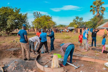 Jos East, Plateau State, Nijerya - 12 Mayıs 2021: Kırsal kesimlerde elle su kuyusu kurulumu. Nijerya Afrika 'daki SDG Hedefleri. Bir grup Afrikalı elle su pompalamaya çalışıyor..