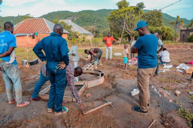 Jos East, Plateau State, Nijerya - 12 Mayıs 2021: Kırsal kesimlerde elle su kuyusu kurulumu. Nijerya Afrika 'daki SDG Hedefleri. Bir grup Afrikalı elle su pompalamaya çalışıyor..