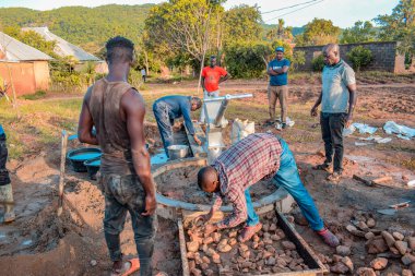 Jos East, Plateau State, Nijerya - 12 Mayıs 2021: Kırsal kesimlerde elle su kuyusu kurulumu. Nijerya Afrika 'daki SDG Hedefleri. Bir grup Afrikalı elle su pompalamaya çalışıyor..