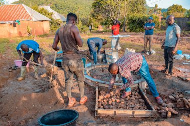 Jos East, Plateau State, Nijerya - 12 Mayıs 2021: Kırsal kesimlerde elle su kuyusu kurulumu. Nijerya Afrika 'daki SDG Hedefleri. Bir grup Afrikalı elle su pompalamaya çalışıyor..