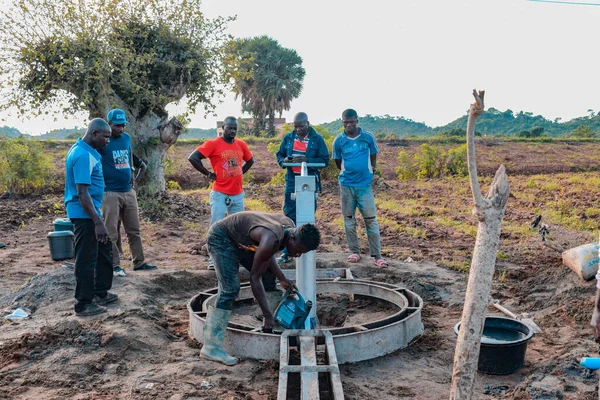 Jos East, Plateau State, Nijerya - 12 Mayıs 2021: Kırsal kesimlerde elle su kuyusu kurulumu. Nijerya Afrika 'daki SDG Hedefleri. Bir grup Afrikalı elle su pompalamaya çalışıyor..