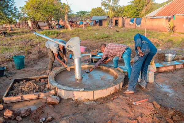 stock image Jos East, Plateau State, Nigeria - May 12, 2021: Group of africans people working of installing hand pump water well.