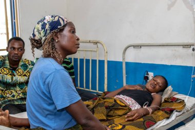 Opialu, Benue State - 6 Mart 2021: Afrikalı anne kırsal bir klinikte hasta kızına bakıyor