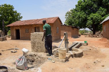 Karara, Nasarawa Eyaleti - 5 Mayıs 2021: Kırsal bir toplulukta, Güneş Altında Bir Elle Borewell İstasyonu Yapan Afrikalı Adam