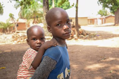 Karara, Nasarawa Eyaleti - 5 Mayıs 2021: Kardeşini sırtında taşıyan Afrikalı Bir Erkek Çocuğun Portresi