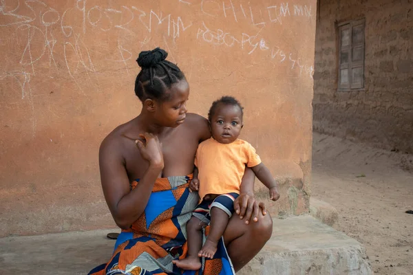 stock image Opialu, Benue State - March 6, 2021: African Mother Sitting Outdoor Tending to her Child