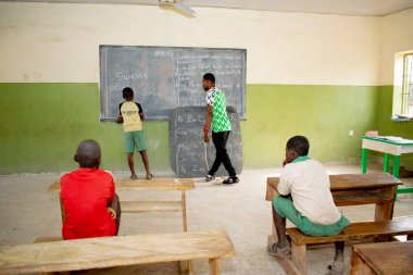 Opialu, Benue State, Nijerya - 6 Mart 2021: Öğrencilerine kırsal kesimde İngilizce öğreten Afrikalı öğretmen