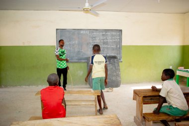 Opialu, Benue State, Nijerya - 6 Mart 2021: Öğrencilerine kırsal kesimde İngilizce öğreten Afrikalı öğretmen