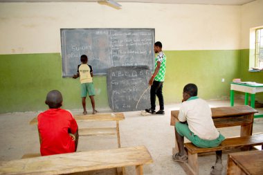 Opialu, Benue State, Nijerya - 6 Mart 2021: Öğrencilerine kırsal kesimde İngilizce öğreten Afrikalı öğretmen