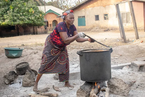 ベニュー州オピアル2021年3月6日 農村環境で薪料理をする中年アフリカ女性の笑顔 — ストック写真