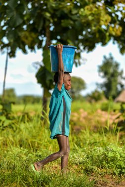 Talata, Plato Eyaleti - Haziran 2023: Yeni İnşa Edilen Hint El Pompasından su taşıyan Afrikalı Çocuk. Topluluk Üyeleri Yurtiçi Kullanım İçin Su Getiriyorlar.