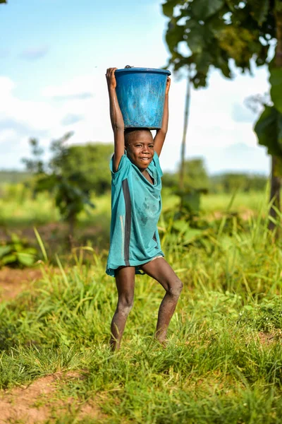 Talata, Plato Eyaleti - Haziran 2023: Yeni İnşa Edilen Hint El Pompasından su taşıyan Afrikalı Çocuk. Topluluk Üyeleri Yurtiçi Kullanım İçin Su Getiriyorlar.