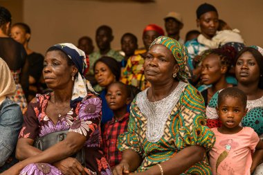Abuja, Nijerya - 15 Ağustos 2023: Kırsal bir toplulukta tıbbi bakım ve dikkat kuyruğunda beklerken Afrika 'da oturmak. Afrika 'daki Siyasi Kampanya