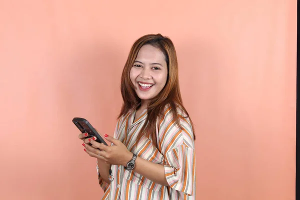 Feliz Hermosa Mujer Asiática Sosteniendo Teléfono Inteligente Fondo Del Melocotón —  Fotos de Stock