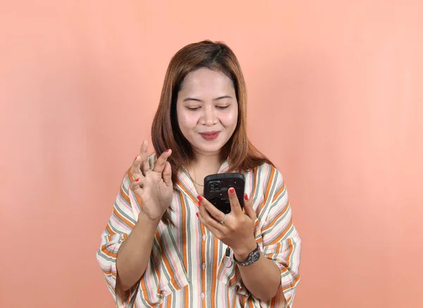 Счастливая Азиатка Отправляет Сообщение Смартфоном Персиковом Фоне — стоковое фото