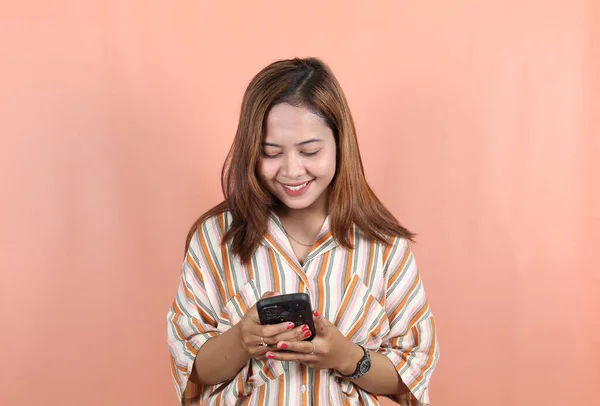 Ευτυχισμένη Όμορφη Ασιάτισσα Γυναίκα Στέλνει Ένα Μήνυμα Smartphone Φόντο Ροδακινί — Φωτογραφία Αρχείου