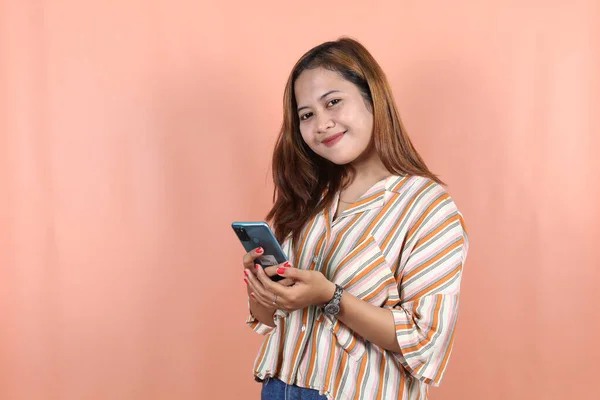 Glücklich Schöne Asiatin Hält Smartphone Auf Pfirsichhintergrund — Stockfoto
