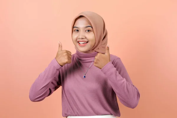 美丽的年轻的亚洲穆斯林妇女穿着紫色衣服高兴地举起两个大拇指 — 图库照片