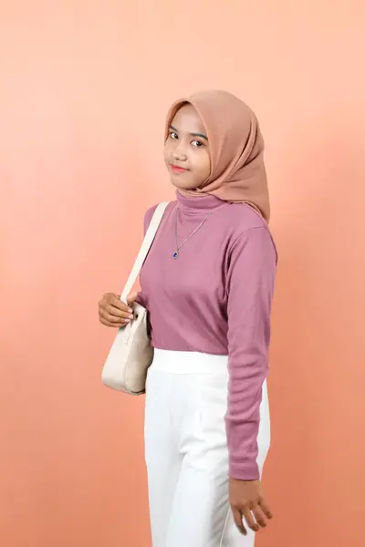 美しい若いアジアのイスラム教の女性は 自信を持って白いファッションバッグを運ぶことを楽しみに笑っています — ストック写真