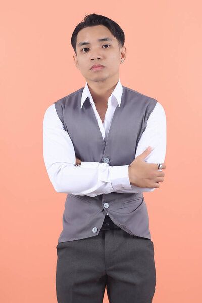 Handsome young Asian businessman wearing a suit vest looks forward with boss-like confidence and holds his hands on his chest. company evaluation, coordination hopeful