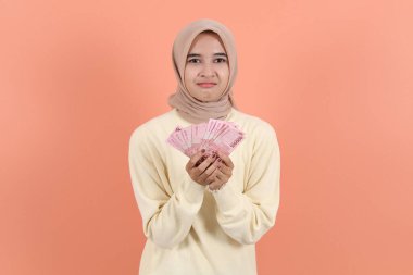 Güzel Asiam müslüman kadın para gösteriyor rupiah