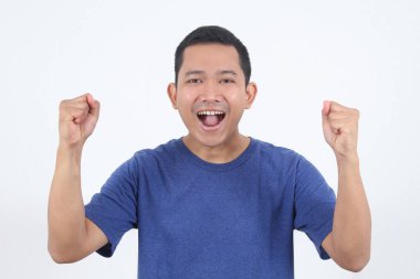 Zeki, çekici, Asyalı arkadaş canlısı erkek el ayağa kalkar neşeli bir şekilde ayağa kalkar ve ferahlık ve neşe dolu mavi tişört portresi ile gülümser beyaz arka plan