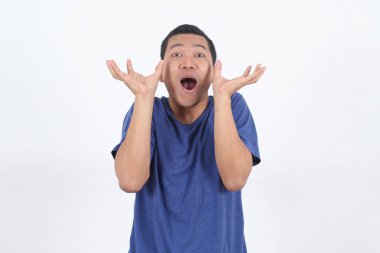 Şaşırmış Asyalı adam beyaz arka planda reklam için ellerini kaldırarak yukarı bakıyor..