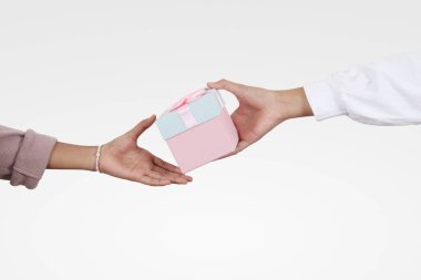 Bir eliyle pembe ve mavi bir hediye veriyor pembe kurdeleli ve diğer eliyle kabul ediliyor.