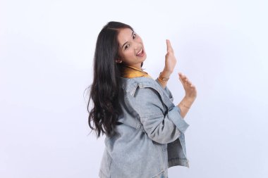 Neşeli Asyalı kadın dişleri gülümsüyor geriye bakıyor mavi ceket giyiyor sarı tişört izole edilmiş beyaz arka plan