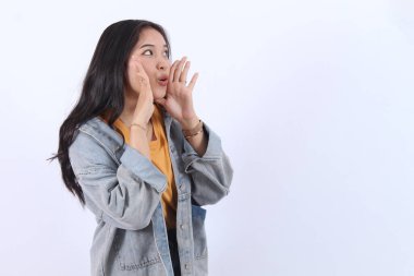 Güzel Asyalı kadın, ağzı açık ellerini kaldırıyor pembe arka planda iyi haberler bağırıyor..