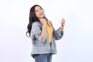 Mutlu Asyalı kadın elinde akıllı bir telefonla ödülü kazanıyor.