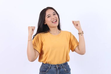 Heyecanlı genç Asyalı kadın, ellerini kaldırarak başarıyı kutluyor. Neşeli, pozitif, elleri havada, ağzı açık bir Asyalı kadın. Mutlu beyaz bir arka plan, kopyalama alanı.