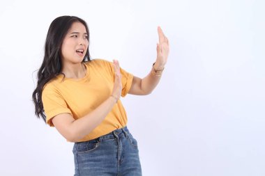 Kes şunu! Endişeli Asyalı kadın reddetme işareti gösteriyor, hayır diyor, farkındalığı arttırıyor, beyaz arka planda duruyor.