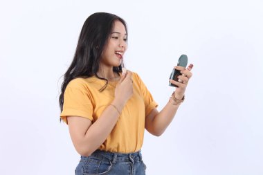 Güzel bir Asyalı kadın elinde küçük bir aynayla ruj kullanıyor. Makyaj modası güzelliği izole edilmiş beyaz bir arka plan.