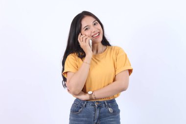 Dost canlısı gülümseyen Asyalı kadın telefonda konuşuyor, nöbetçi kız, akıllı telefonu tutuyor ve gülüyor, konuşuyor, beyaz arka planda duruyor.