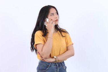 Dost canlısı gülümseyen Asyalı kadın telefonda konuşuyor, nöbetçi kız, akıllı telefonu tutuyor ve gülüyor, konuşuyor, beyaz arka planda duruyor.