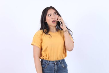 Dost canlısı gülümseyen Asyalı kadın telefonda konuşuyor, nöbetçi kız, akıllı telefonu tutuyor ve gülüyor, konuşuyor, beyaz arka planda duruyor.