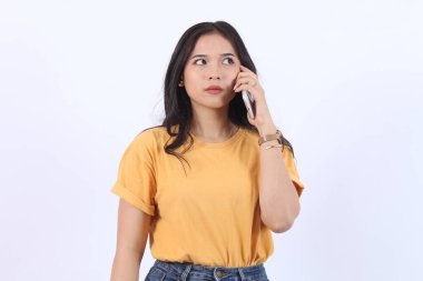 Dost canlısı gülümseyen Asyalı kadın telefonda konuşuyor, nöbetçi kız, akıllı telefonu tutuyor ve gülüyor, konuşuyor, beyaz arka planda duruyor.