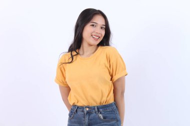 Kendine güvenen neşeli Asyalı kadın kameraya bakıyor sarı tişört giyiyor izole edilmiş beyaz arka plan