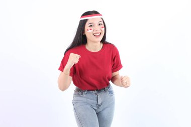 17 Ağustos 'ta Endonezya' nın bağımsızlığını kutlamak için ellerini sıkan genç Asyalı kadın, kırmızı başlık ve bayraklarla kendinden emin ve heyecanlı bir ifadeyle kameraya baktı.