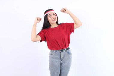 17 Ağustos 'ta Endonezya' nın bağımsızlığını kutlamak için ellerini sıkan genç Asyalı kadın, kırmızı başlık ve bayraklarla kendinden emin ve heyecanlı bir ifadeyle kameraya baktı.