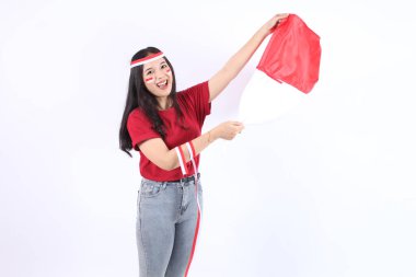 Heyecanlı genç ve güzel Asyalı kadın Endonezya 'nın bağımsızlık gününü 17 Ağustos' ta beyaz arka planda izole edilmiş kırmızı beyaz bayraklı bayrağıyla kutluyor.