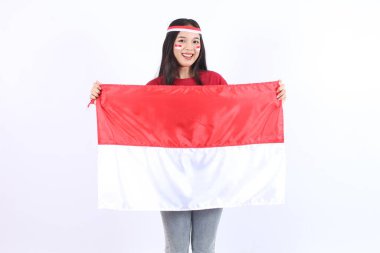 Heyecanlı genç ve güzel Asyalı kadın Endonezya 'nın bağımsızlık gününü 17 Ağustos' ta beyaz arka planda izole edilmiş kırmızı beyaz bayraklı bayrağıyla kutluyor.