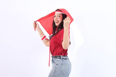 Heyecanlı genç ve güzel Asyalı kadın Endonezya 'nın bağımsızlık gününü 17 Ağustos' ta beyaz arka planda izole edilmiş kırmızı beyaz bayraklı bayrağıyla kutluyor.