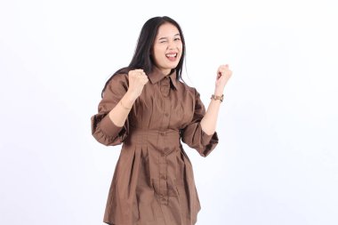 Heyecanlı genç Asyalı kadın ellerini kaldırarak başarıyı kutluyor gülümsüyor elleri ve elleri açık neşeli Asyalı kadın mutlu oluyor, beyaz fotokopi odasında izole edilmiş hayatın tadını çıkarıyor.