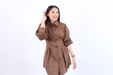 Mutlu genç Asyalı kadın beyaz arka planda dururken neşeli yüz ifadesi