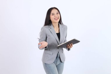Gri ceketli güzel bir kadın elinde bir kitapla sunum yapıyor. Gülümsüyor ve mutlu. İş kadını Asyalı kadın